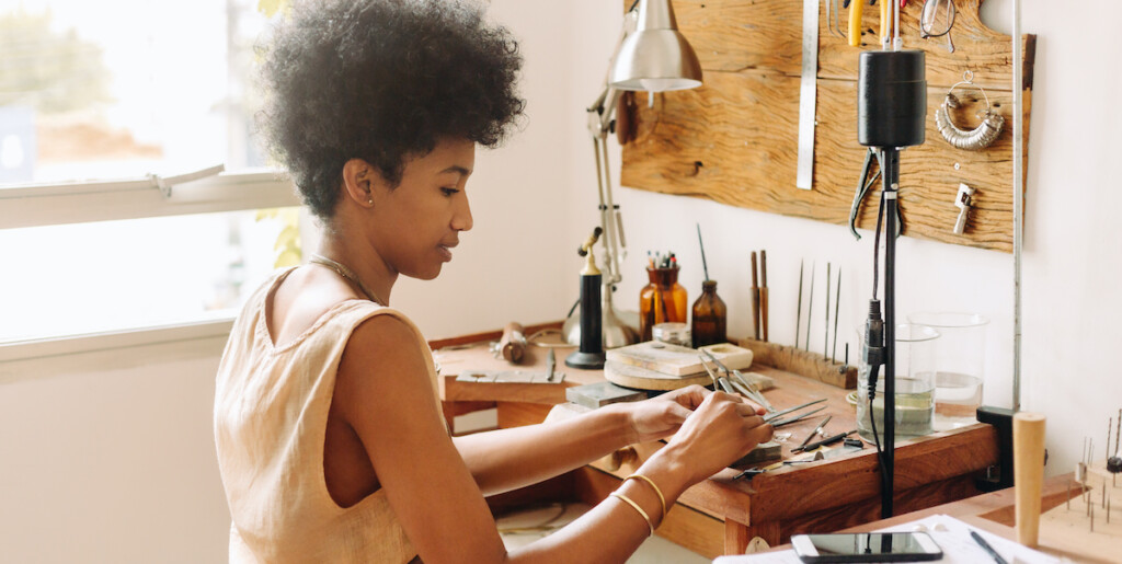 Woman making handmade jewelry in her workshop