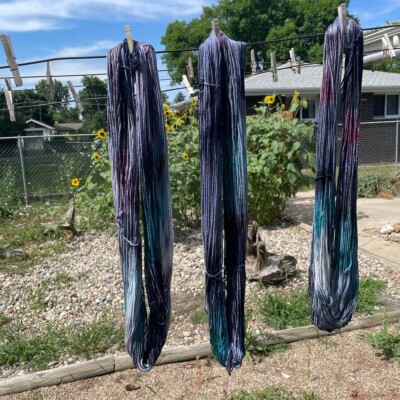 Ice-dyed yarn in a saturated variegated colorway hanging to dry