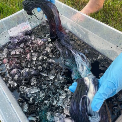 Pulling dyed yarn out of the ice dye bath