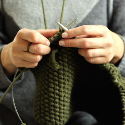 Close up of woman knitting green yarn